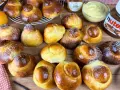 Tanti brioche col tuppo dorati, alcuni spolverati di zucchero a velo, pronti per essere farciti con crema o Nutella.