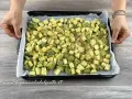 Zucchine gratinate al forno pronte per essere infornate, tagliate a cubetti e cosparse di pangrattato.