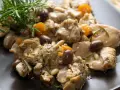 Coniglio alla ligure con olive, pinoli e rosmarino, un piatto saporito e profumato.