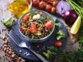 Un'insalata di lenticchie fresca e colorata, con pomodorini, cetrioli e spinacini, pronta per essere gustata.