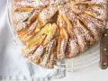 Deliziosa torta di mele in friggitrice ad aria, spolverata di zucchero a velo, con una fetta tagliata per mostrare il morbido interno.