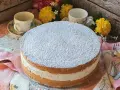 Torta Kinder Paradiso soffice e cremosa, cosparsa di zucchero a velo, pronta per essere gustata con un tè.