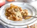 Un delizioso crumble di mele appena sfornato, con mele caramellate e una croccante copertura dorata.