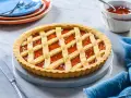 Una deliziosa crostata di marmellata con una griglia dorata di pasta frolla, pronta per essere gustata.