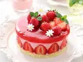 Deliziosa bavarese alle fragole, ricoperta da una gelatina rossa brillante e decorata con fragole fresche, menta e fiorellini bianchi.