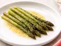 Asparagi in padella, cotti alla perfezione e conditi con un leggero sughetto.