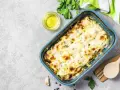 Zucchine al forno con mozzarella filante, dorate e profumate, pronte per essere gustate.