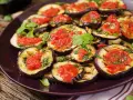 Fette di melanzane grigliate condite con salsa di pomodoro e basilico, un piatto invitante di melanzane alla pizzaiola.