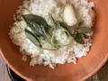 Riso in cagnone, profumato con aglio e salvia croccante, servito in una ciotola di terracotta.