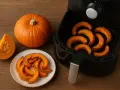 Fette di zucca dorate e cotte nella friggitrice ad aria, pronte per essere gustate.