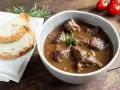 Cinghiale in umido fatto in casa da Benedetta, servito in una ciotola con pane tostato e rosmarino.