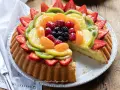 Una deliziosa crostata morbida alla frutta, con fragole, kiwi, mandarini e frutti di bosco, su una base soffice e crema pasticcera.