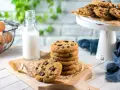 Una pila di deliziosi biscotti con gocce di cioccolato, pronti per essere gustati con un bicchiere di latte.