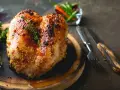 Petto di pollo al forno dorato e succulento, condito con senape e erbe aromatiche, pronto per essere gustato.
