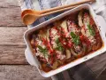 Parmigiana di melanzane appena sfornata, con melanzane, pomodoro, mozzarella filante e basilico fresco.