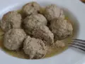 Polpette in umido, morbide e succulente, servite in un piatto bianco con un sughetto invitante.