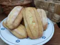 Biscotti da inzuppo dorati e zuccherati, perfetti per la colazione o la merenda. Sullo sfondo, un cestino di uova e un altro intrecciato.