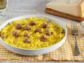 Un invitante risotto alla monzese, giallo intenso e arricchito da pezzetti di salsiccia, pronto per essere gustato.