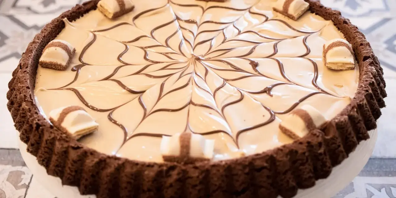 Torta Kinder Bueno con decorazione a ragnatela in cioccolato e pezzi di wafer.