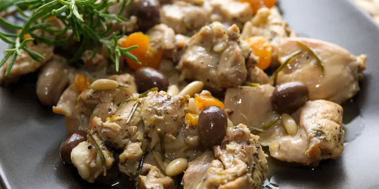 Coniglio alla ligure con olive, pinoli e rosmarino, un piatto saporito e profumato.
