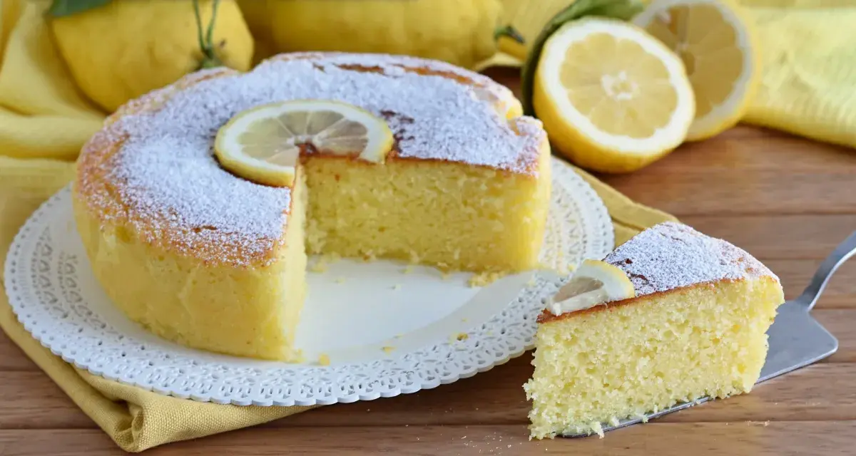 Una soffice torta ricotta e limone, spolverata di zucchero a velo e decorata con fettine di limone. Perfetta per una pausa golosa.
