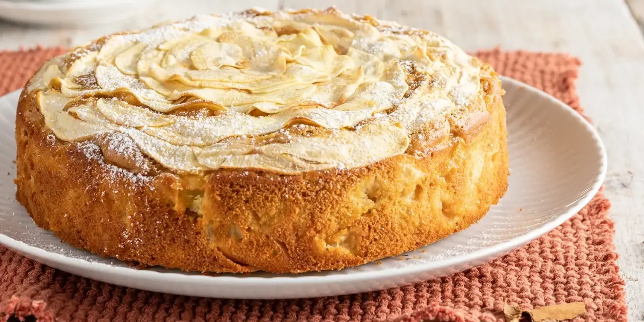 Deliziosa torta di mele senza burro, con mele a rosa sulla superficie e una spolverata di zucchero a velo. Perfetta per la colazione o la merenda.