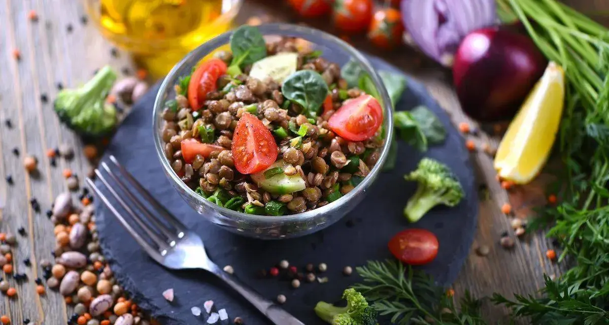 Un'insalata di lenticchie fresca e colorata, con pomodorini, cetrioli e spinacini, pronta per essere gustata.