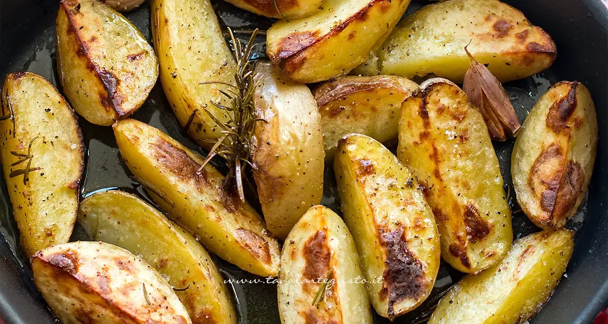 Patate al forno dorate e croccanti, condite con rosmarino e aglio, pronte per essere gustate.