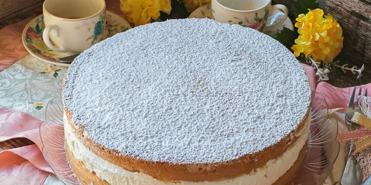Torta Kinder Paradiso soffice e cremosa, cosparsa di zucchero a velo, pronta per essere gustata con un tè.