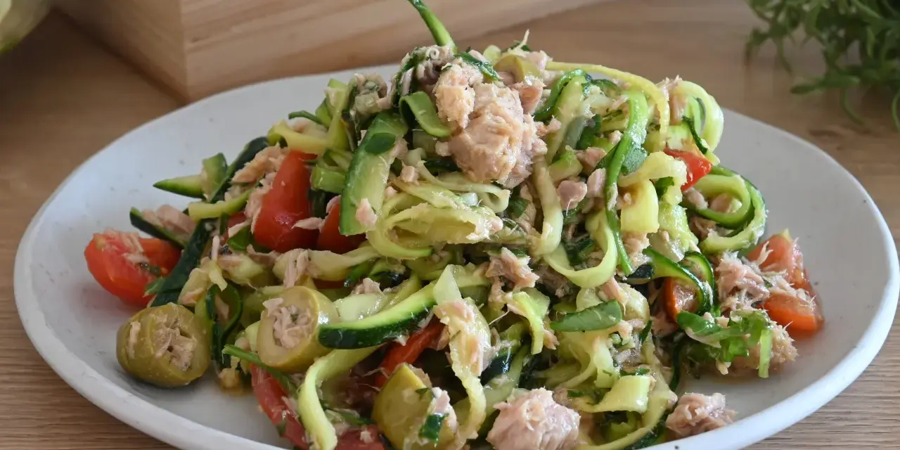 Deliziosa insalata di zucchine a spirale con tonno, pomodorini e olive verdi. Un piatto fresco e leggero.