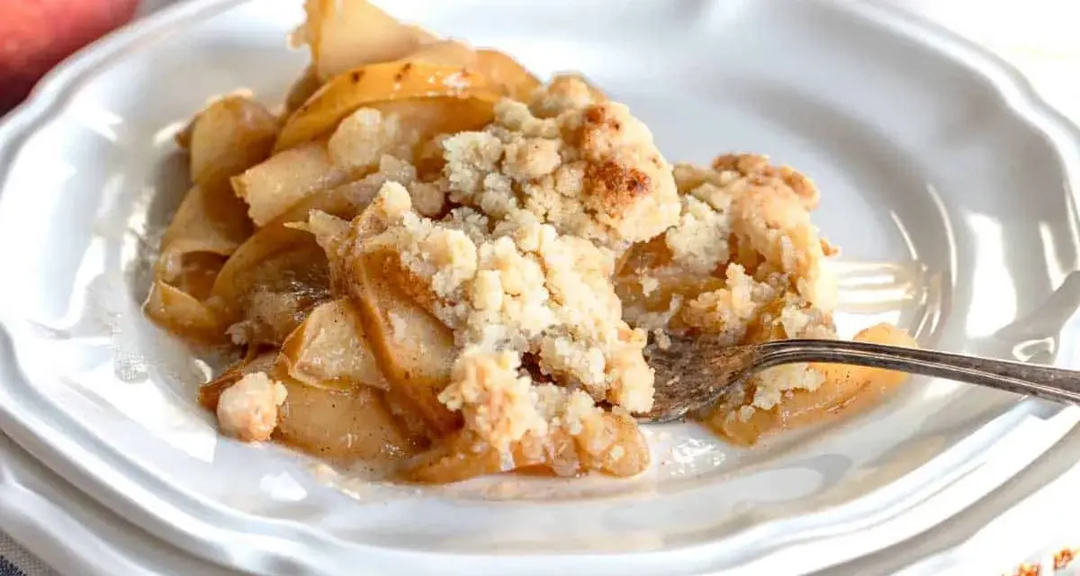 Un delizioso crumble di mele appena sfornato, con mele caramellate e una croccante copertura dorata.