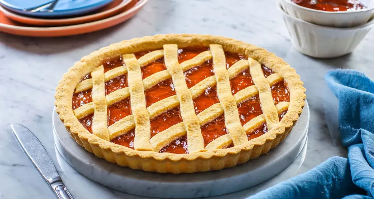 Una deliziosa crostata di marmellata con una griglia dorata di pasta frolla, pronta per essere gustata.
