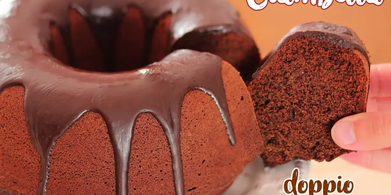 Ciambellone al cioccolato con glassa fondente che cola. Una fetta viene sollevata, mostrando la morbidezza dell'impasto.