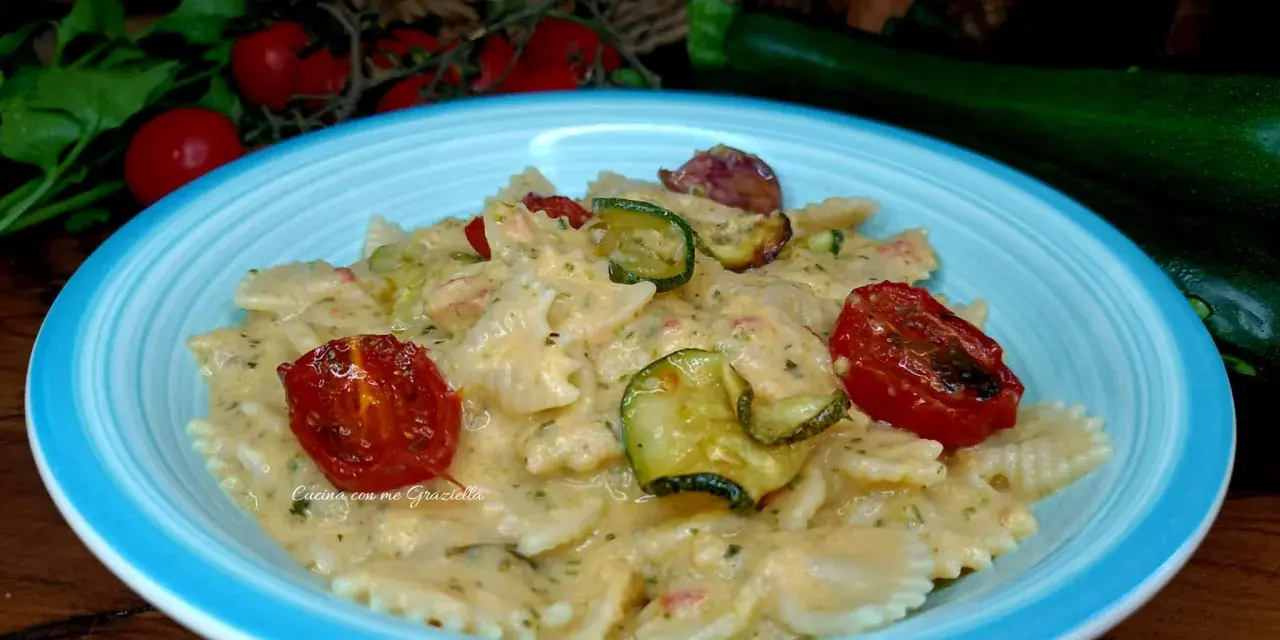 Farfalle cremose con zucchine e pomodorini confit, un piatto che celebra la pasta zucchine e philadelphia.