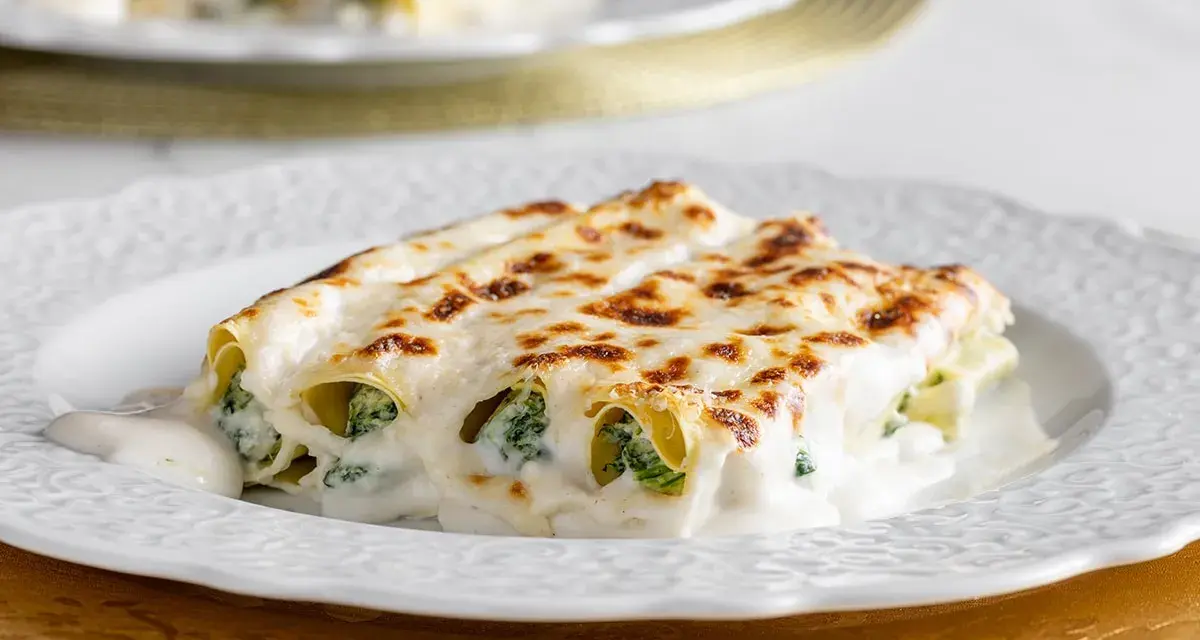 Cannelloni ricotta e spinaci dorati al forno, ricoperti da una cremosa besciamella e formaggio fuso.
