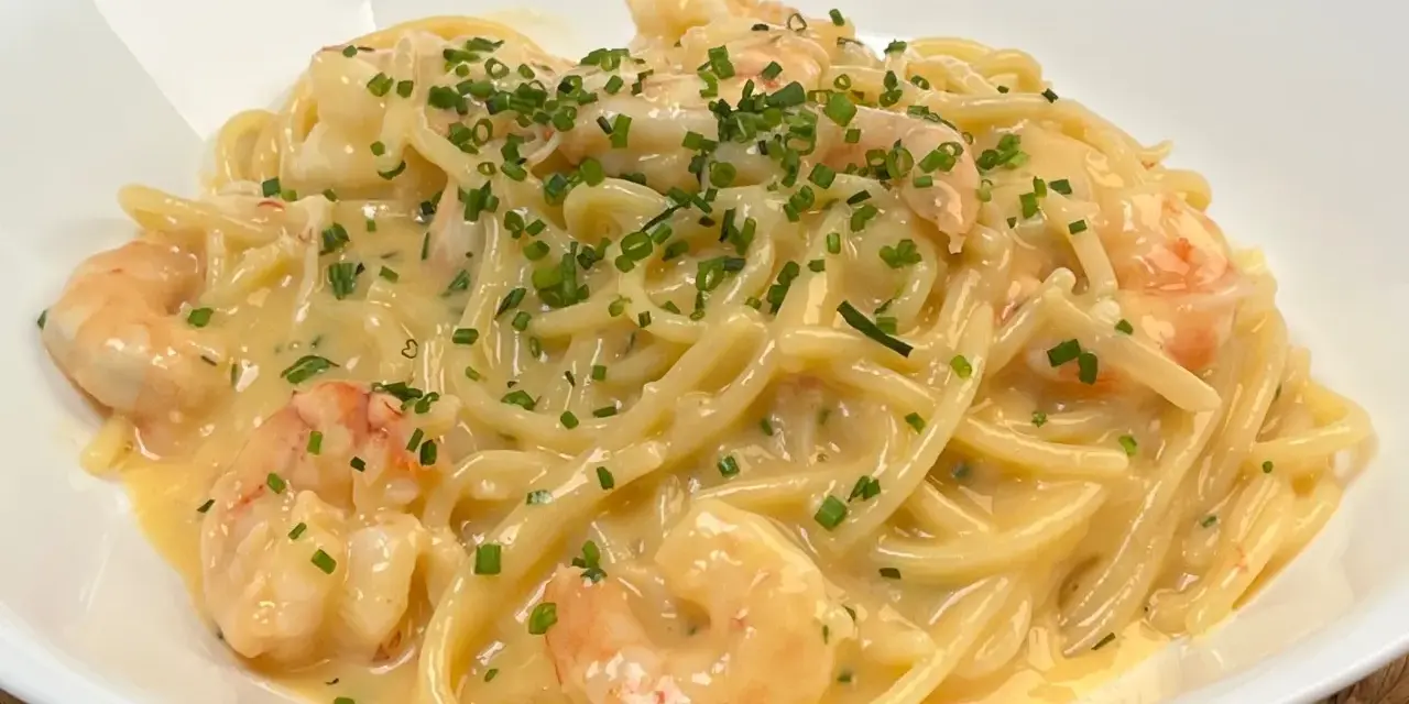 Spaghetti cremosi con gamberi e erba cipollina, una deliziosa carbonara di mare.