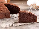 Una fetta di torta al cioccolato soffice e invitante, appena sfornata, su un tavolo di legno.