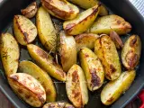 Patate al forno dorate e croccanti, condite con rosmarino e aglio, pronte per essere gustate.