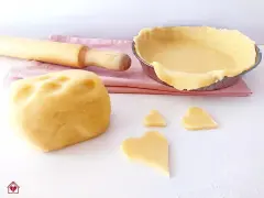 Impasto per pasta frolla senza glutine pronto per essere trasformato in dolci cuori e una crostata.