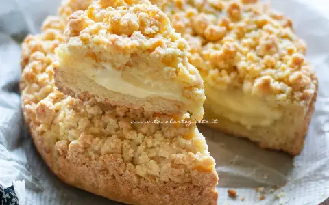 Sbriciolata alla crema, con la sua crosta dorata e il ripieno morbido, è un dolce che invita a un morso goloso.