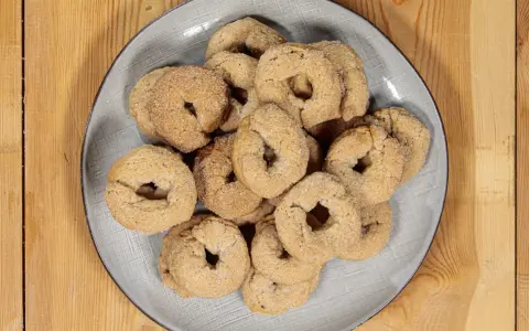 Piatto di ciambelline al vino, dolcetti friabili e dorati, perfetti per accompagnare un caffè o un tè.