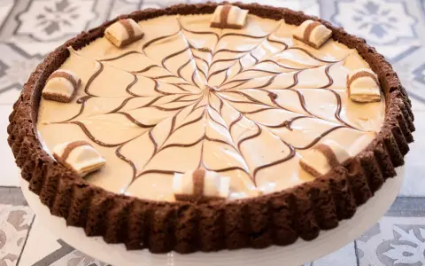 Torta Kinder Bueno con decorazione a ragnatela in cioccolato e pezzi di wafer.