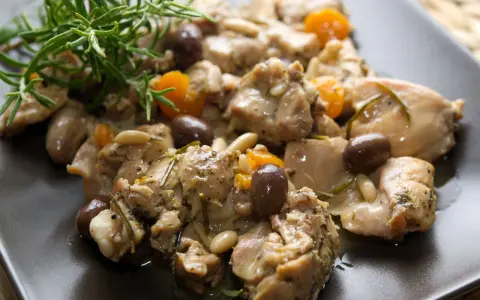 Coniglio alla ligure con olive, pinoli e rosmarino, un piatto saporito e profumato.