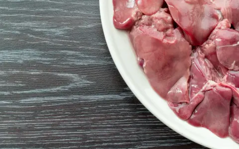 Un piatto bianco pieno di **durelli di pollo** crudi, pronti per essere cucinati.