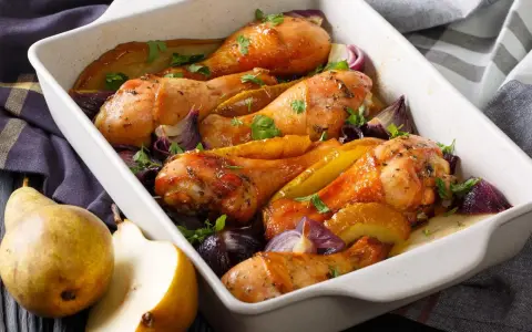 Cosce di pollo al forno dorate con pere, cipolle rosse e prezzemolo, un piatto succulento e profumato.