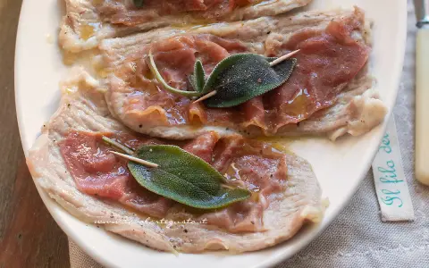 Saltimbocca alla romana: fettine di vitello con prosciutto crudo e salvia, condite con olio e pepe.