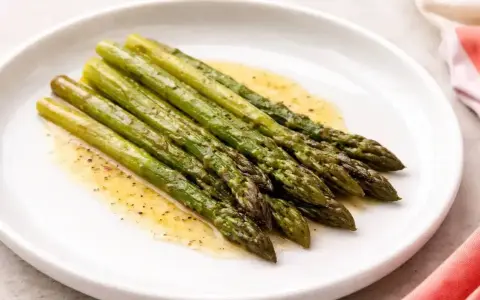 Asparagi in padella, cotti alla perfezione e conditi con un leggero sughetto.