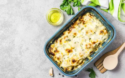 Zucchine al forno con mozzarella filante, dorate e profumate, pronte per essere gustate.