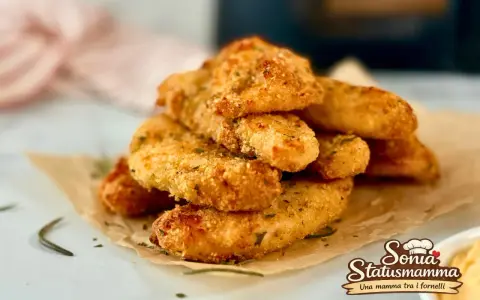 Croccanti bastoncini di pollo in friggitrice ad aria, dorati e saporiti, perfetti per un pasto veloce e gustoso.