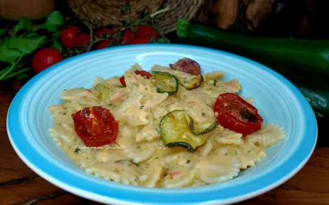 Farfalle cremose con zucchine e pomodorini confit, un piatto che celebra la pasta zucchine e philadelphia.